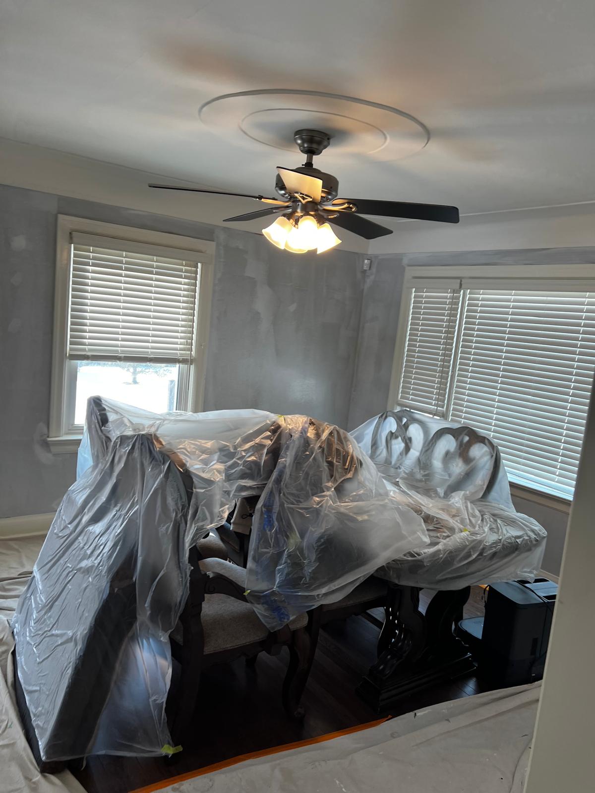 Dining room with furniture protected and walls being painted