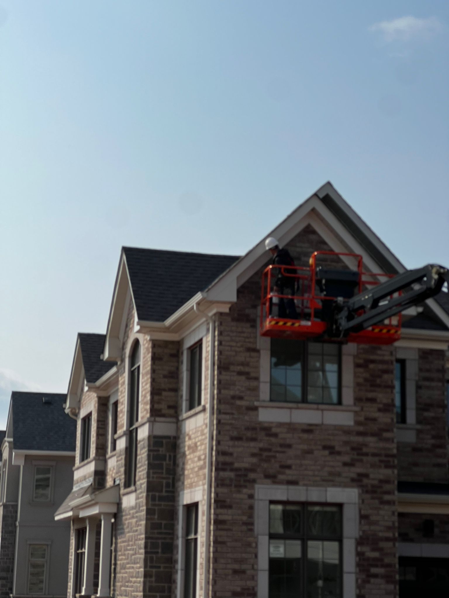 Exterior painting using cherry picker on multi-story building