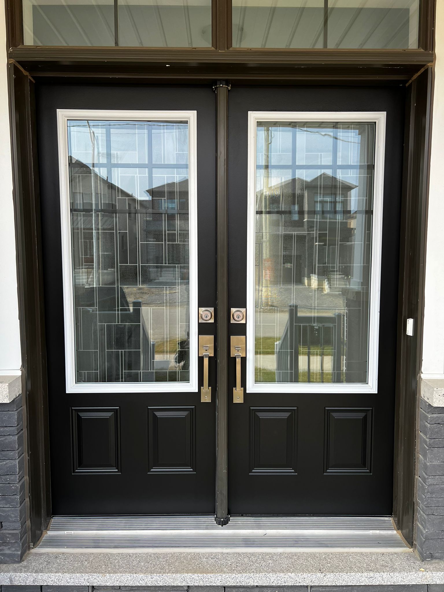 Freshly painted black double front doors with glass panels