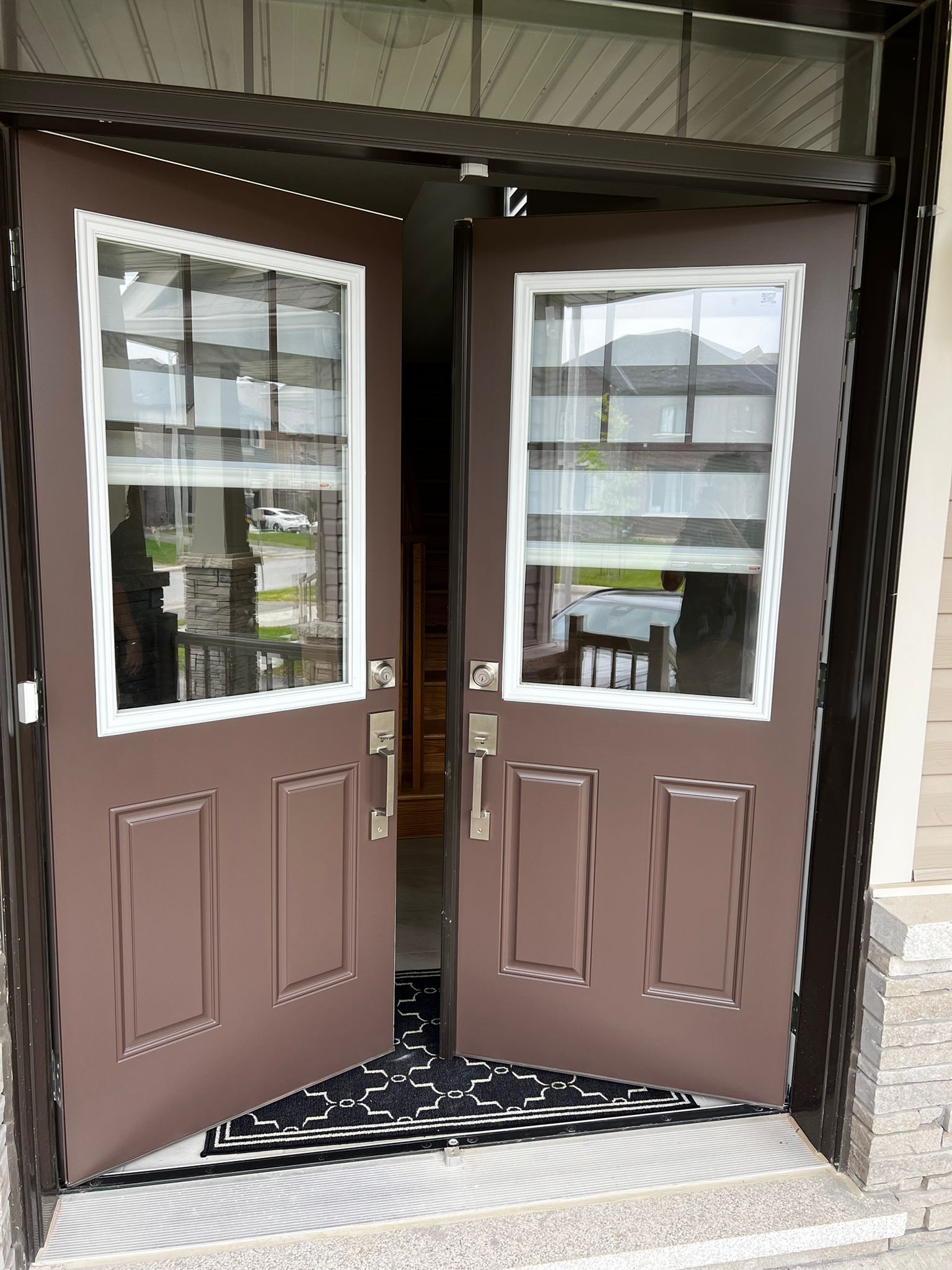 Finished brown double front doors after professional painting