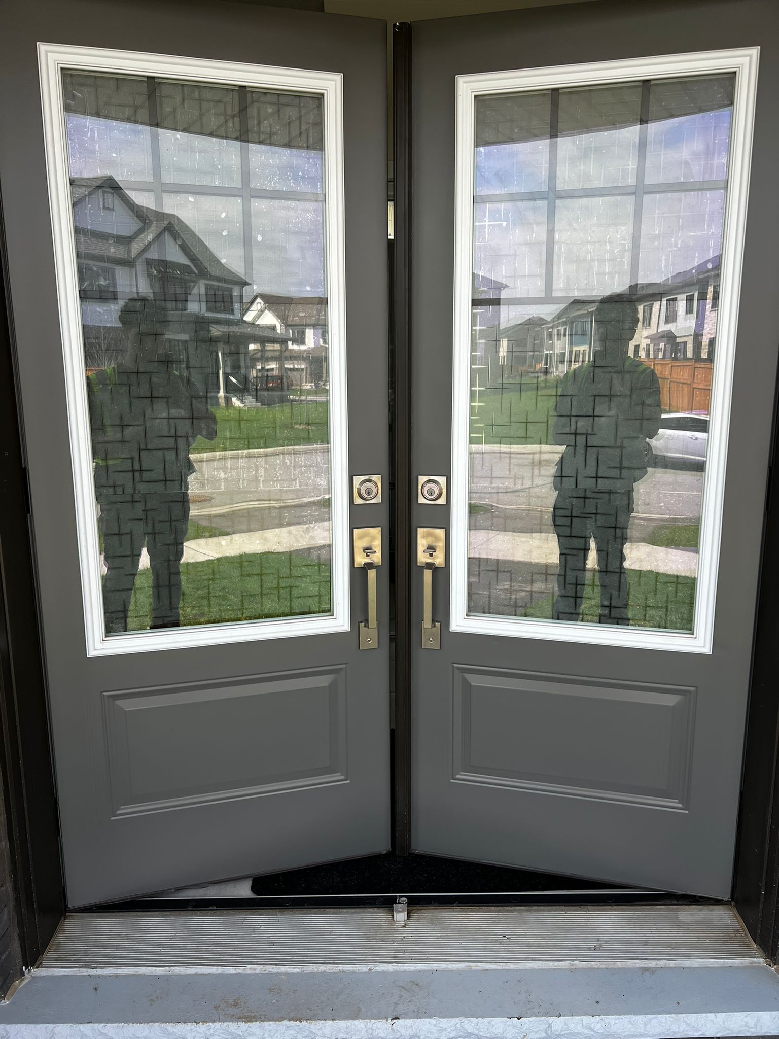 Gray painted double front doors with brass hardware