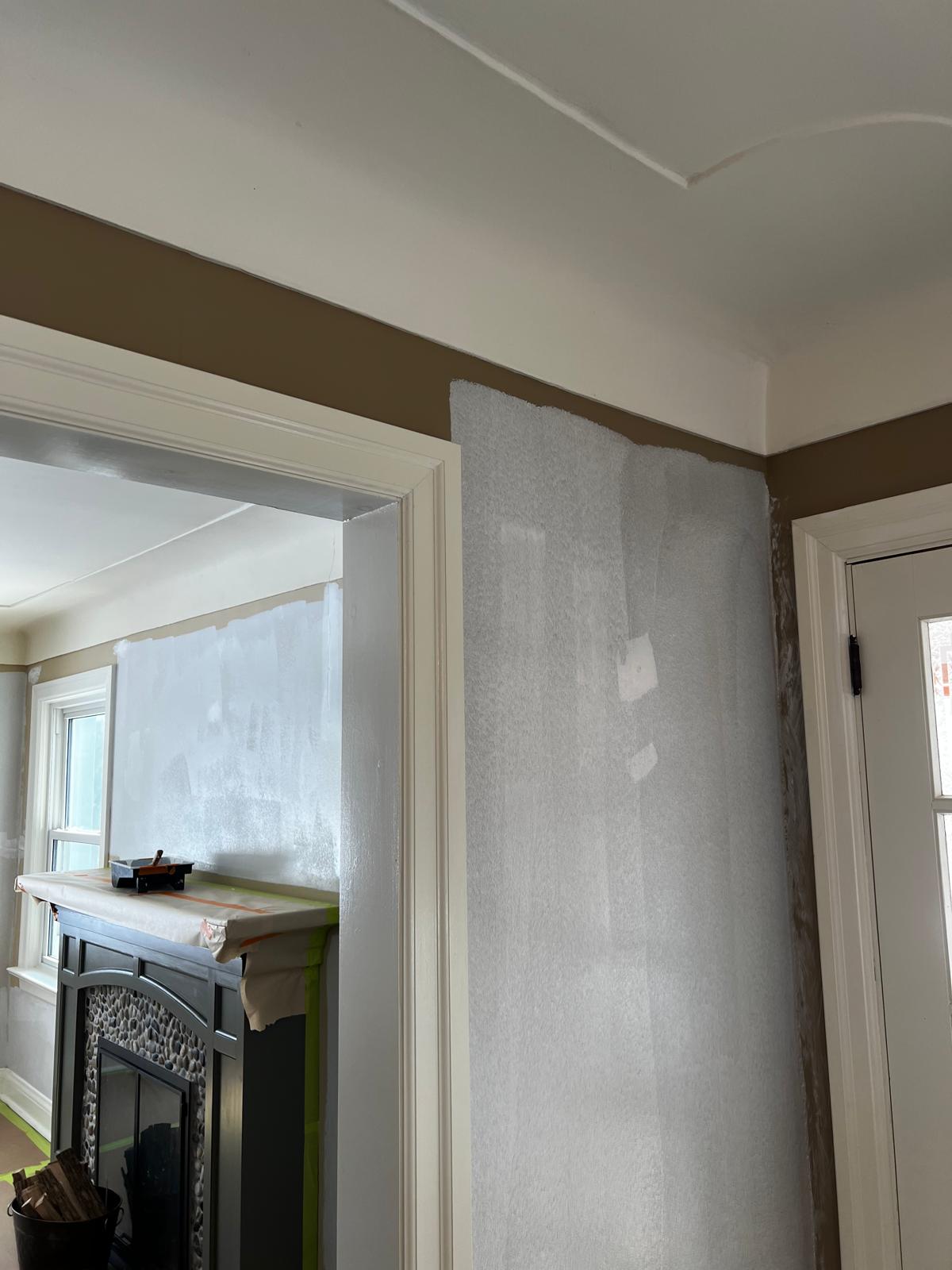 Living room with fireplace area receiving primer coat