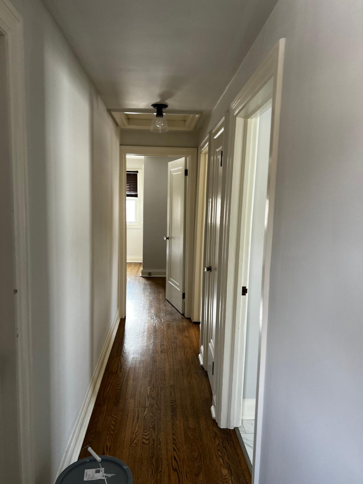 Freshly painted hallway with clean white walls and hardwood floors