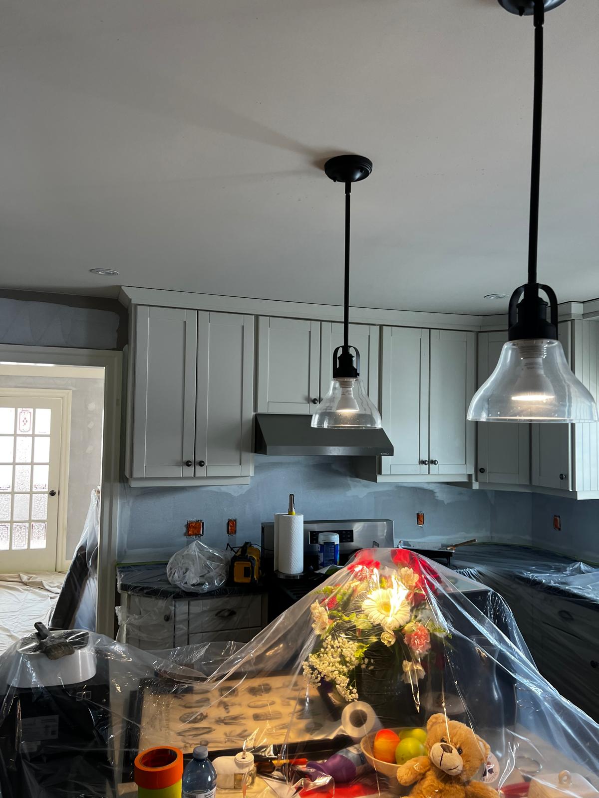 Kitchen with painted cabinets and pendant lights during renovation