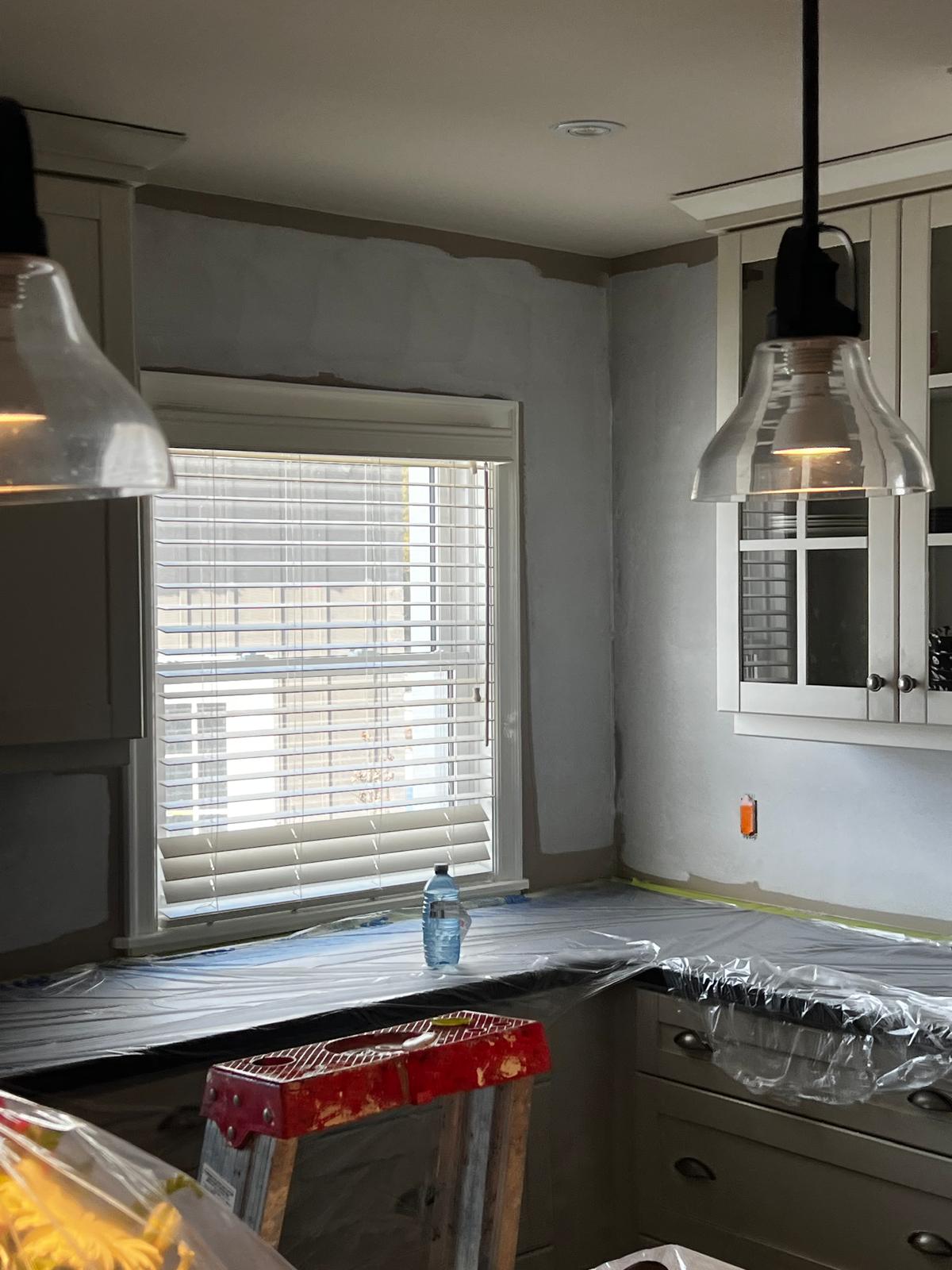 Kitchen area with cabinets and walls being painted