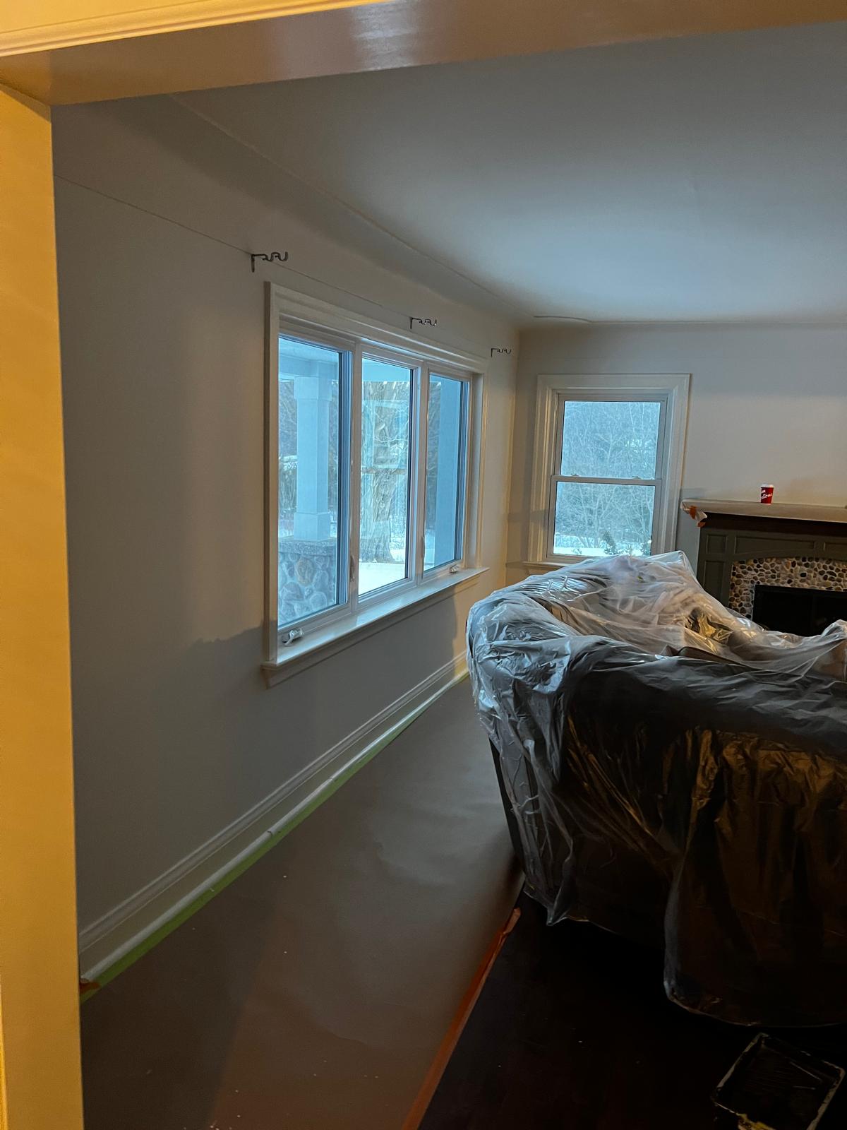 Living room with large windows and primer on walls
