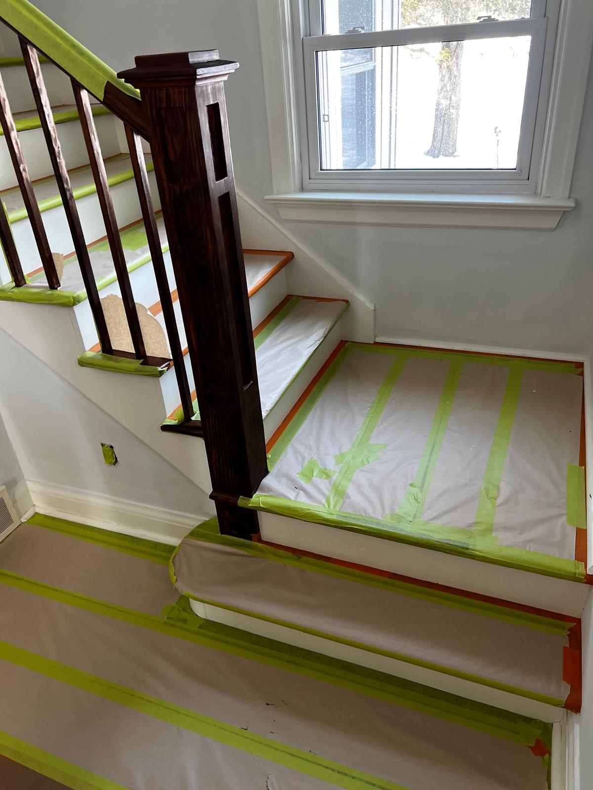 Staircase landing with protective coverings and fresh paint