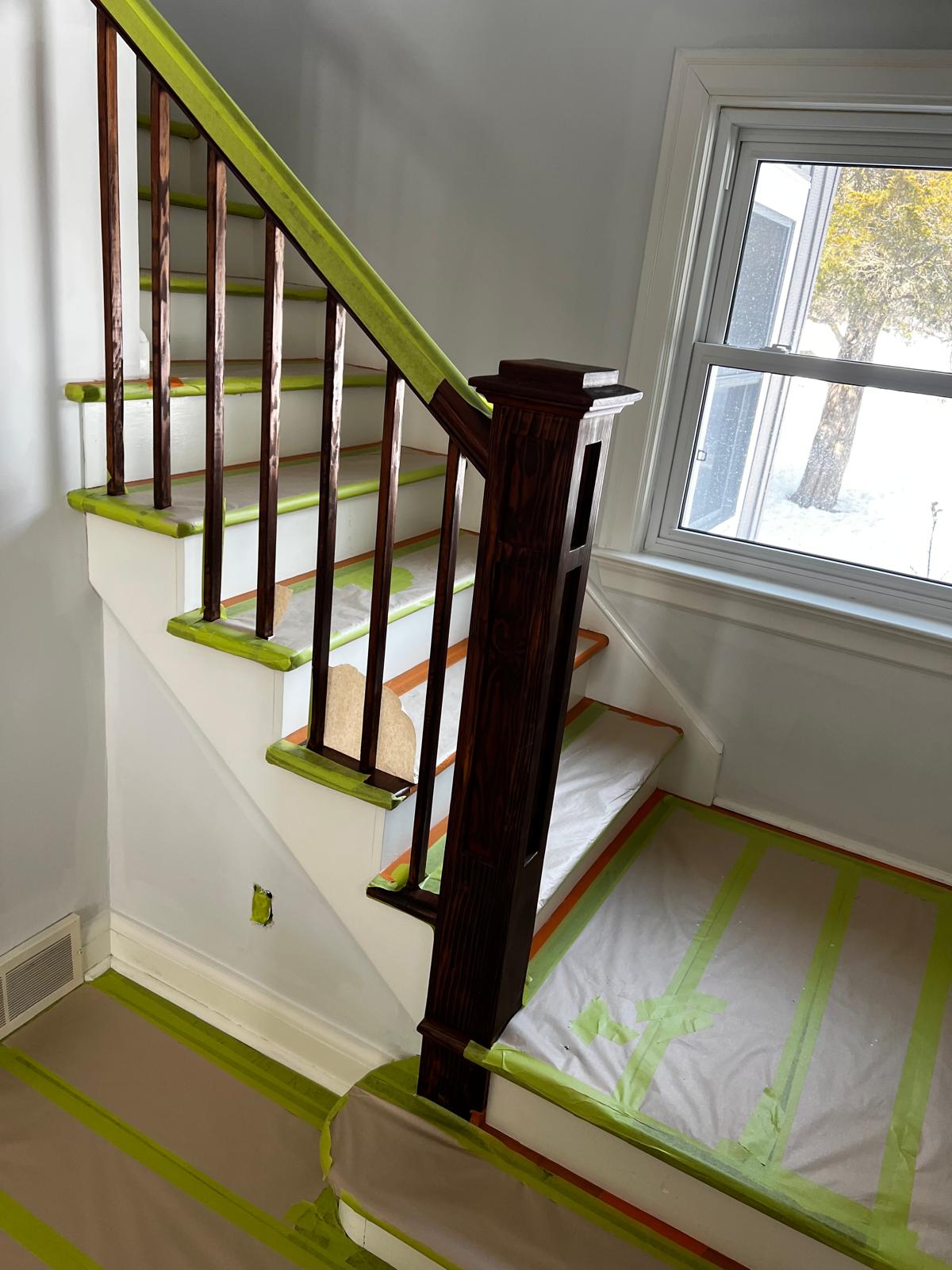 Staircase with dark wood railing and freshly painted white walls